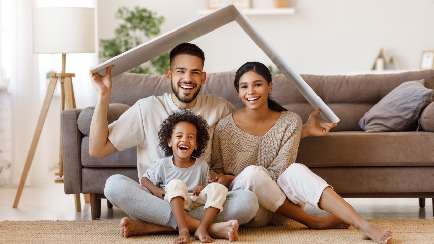 mortgage loans near syracuse ny image of happy family playing in the living room of their new home with fake roof