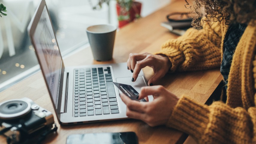 credit card rates near syracuse ny image of woman using her credit card on her laptop