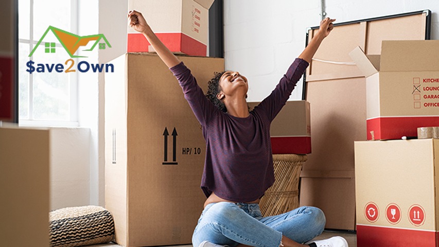 saving to buy a home save2own woman celebrating with moving boxes