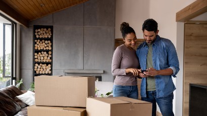 Online Mortgage Application near syracuse ny panel image for rates couple looking at phone while packing up moving boxes for new house mortgage